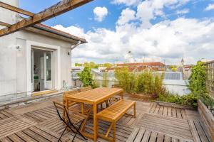 a wooden table and chairs on a wooden deck at Grand penthouse Parisien pour 10 personnes in Pierrefitte-sur-Seine