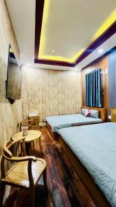une chambre d'hôtel avec deux lits et une table dans l'établissement GIA BẢO TÂY ĐÔ 3 Hotel, à Ấp Bình Thương 15 autres photos