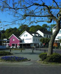 a town with white buildings and a tree and flowers at Hostellerie Valckenborgh - Lodging Only in Valkenburg