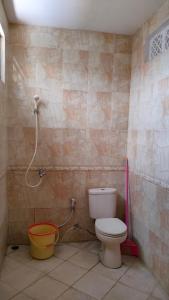 ein Badezimmer mit Toilette und Dusche in der Unterkunft Purikafilla Homestay in Timuran
