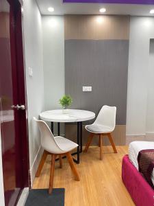 a room with a table and two chairs and a bed at Family Inn - Airport Hotel in Dhaka