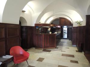 eine Bar in einem Restaurant mit einer Person hinter der Theke in der Unterkunft Hotel Praha in Broumov