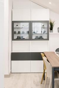 a dining room with white and black cabinets at Botanic Apartments - Suite in Naples