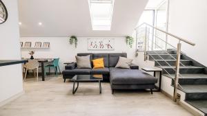 a living room with a couch and a staircase at Botanic Apartments - Suite in Naples