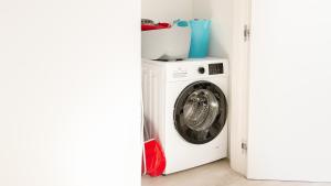 a washing machine in a room next to a door at Botanic Apartments - Suite in Naples