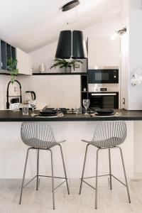 a kitchen with two chairs at a kitchen counter at Botanic Apartments - Suite in Naples