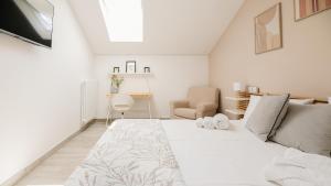 a white bedroom with a bed and a desk at Botanic Apartments - Suite in Naples