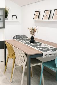 a dining room table with two chairs and a vase with flowers at Botanic Apartments - Suite in Naples