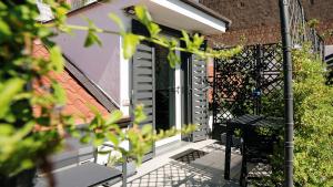 a window with black shutters on a house at Botanic Apartments - Suite in Naples