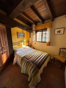 a bedroom with a bed and a chair in a room at Casa Rural Los Cuartos de Gredos in Los Cuartos