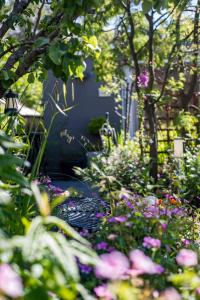 a garden filled with lots of flowers and trees at Cabin for two Christchurch in Hinton +4 photos