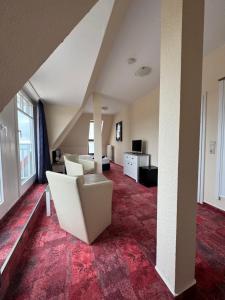 a living room with a couch and a chair in a room at Strandhotel Dünenhaus in Juliusruh