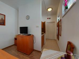 a living room with a tv on a wooden cabinet at Bükkszék Apartmanok in Bükkszék