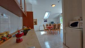 a kitchen and dining room with a table and a refrigerator at Bükkszék Apartmanok in Bükkszék