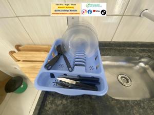 a plastic container with utensils in it next to a sink at Cabo Frio - Braga - Kitnets - Aluguel Econômico in Cabo Frio +279 photos