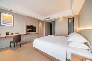 Ένα ή περισσότερα κρεβάτια σε δωμάτιο στο Poltton Century Hotel Yangjiang Jinshan Road