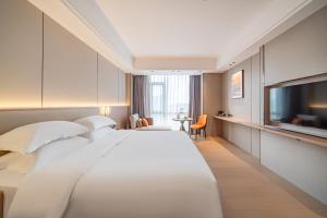 Ένα ή περισσότερα κρεβάτια σε δωμάτιο στο Poltton Century Hotel Yangjiang Jinshan Road