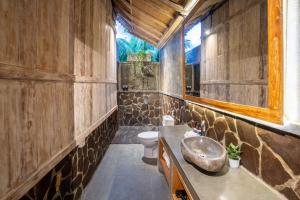 a bathroom with a sink and a toilet at Meraki Luxury Villa in Pemuteran +48 photos