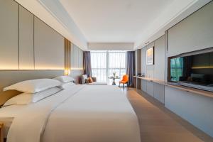 Ένα ή περισσότερα κρεβάτια σε δωμάτιο στο Poltton Century Hotel Yangjiang Jinshan Road