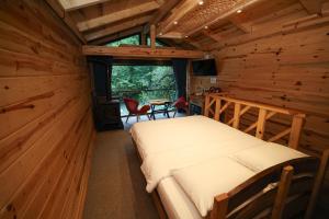 a bedroom with a bed in a log cabin at Kiyi Bungalov in Çamlıhemşin
