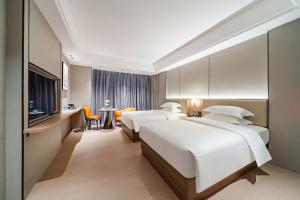 Ένα ή περισσότερα κρεβάτια σε δωμάτιο στο Poltton Century Hotel Yangjiang Jinshan Road