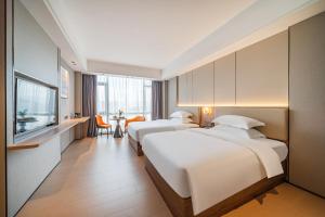 Ένα ή περισσότερα κρεβάτια σε δωμάτιο στο Poltton Century Hotel Yangjiang Jinshan Road