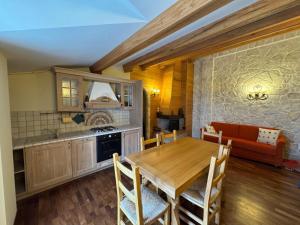 a kitchen and dining room with a wooden table at La Maison in Pescocostanzo