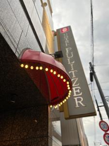 a red light on the side of a building with a sign at ホテルピュリッツァー自由が丘 in Tokyo +13 photos