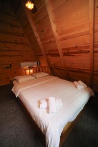 a bed in a wooden room with towels on it at Kiyi Bungalov in Çamlıhemşin