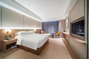 Ένα ή περισσότερα κρεβάτια σε δωμάτιο στο Poltton Century Hotel Yangjiang Jinshan Road