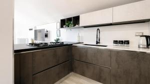 a kitchen with white and brown cabinets and a sink at Botanic Apartments - Suite in Naples