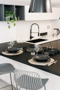a kitchen with black plates and glasses on a counter at Botanic Apartments - Suite in Naples