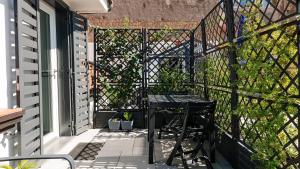 a patio with a table and a fence at Botanic Apartments - Suite in Naples