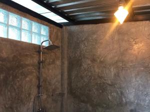 Un baño con ducha con luz y ventana. en 66 Baanaisuan 66 บ้านในสวน, en Ban Komo Sam Sip Paet 67 fotos más