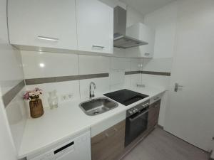 a white kitchen with a sink and a stove at 2 Zimmer Wohnung in Zentrale Lage in Mülheim an der Ruhr