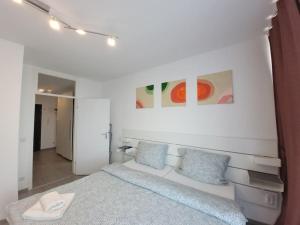 a white bedroom with a bed and blue pillows at 2 Zimmer Wohnung in Zentrale Lage in Mülheim an der Ruhr