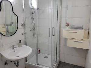 a white bathroom with a sink and a shower at 2 Zimmer Wohnung in Zentrale Lage in Mülheim an der Ruhr