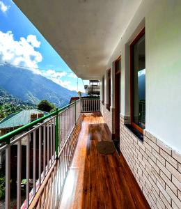 a balcony of a house with a view of the mountains at Yutori Stays in Dharamshala
