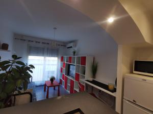 a living room with a table and a room with a tv at Studio et stationnement offert centre hyeres in Hyères
