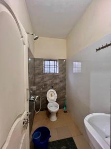 a bathroom with a toilet and a sink at Karkera Family Homestay in Malpe +15 photos