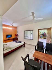 a bedroom with a bed and a table and chairs at Karkera Family Homestay in Malpe