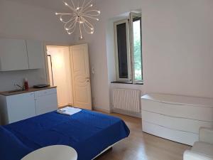 ein kleines Schlafzimmer mit einem blauen Bett und einem Kronleuchter in der Unterkunft RMG Home in Fisciano + 2 Fotos