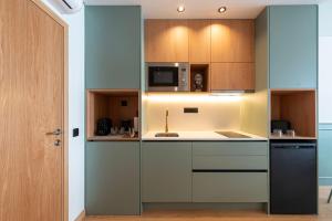 a kitchen with wooden cabinets and a microwave at Doispontozero Alegria Green in Porto +8 photos