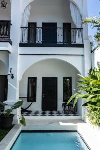 a villa with a swimming pool and a house at Saige House - Room in Shared Villa in Canggu