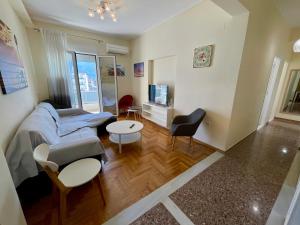 a living room with a couch and a table at Kalamata.House - Sunny and modern apartment with view! in Kalamata