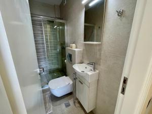 a white bathroom with a sink and a toilet at Kalamata.House - Sunny and modern apartment with view! in Kalamata +29 photos