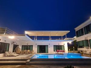 a villa with a swimming pool at night at The Pano Hill in Pak Chong