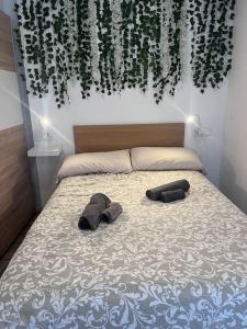 ein Schlafzimmer mit einem Bett mit zwei Hausschuhen darauf in der Unterkunft Design seaview flat next to Yumbo in Playa del Ingles