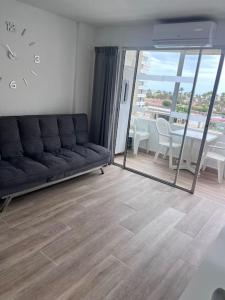 ein Wohnzimmer mit einer Couch und einer Uhr an der Wand in der Unterkunft Design seaview flat next to Yumbo in Playa del Ingles