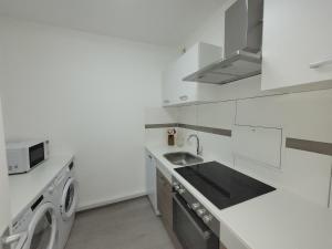 a white kitchen with a sink and a washing machine at 2 Zimmer Wohnung in Zentrale Lage in Mülheim an der Ruhr +13 photos